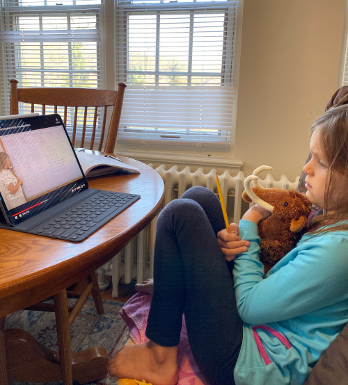 Girl clutching Mathy the mammmoth mascot while watching Maria's math video