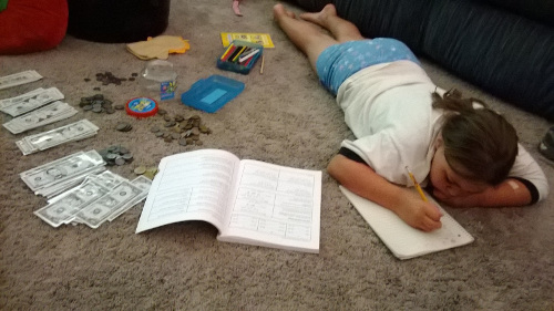 A girl working on money problems from Math Mammoth