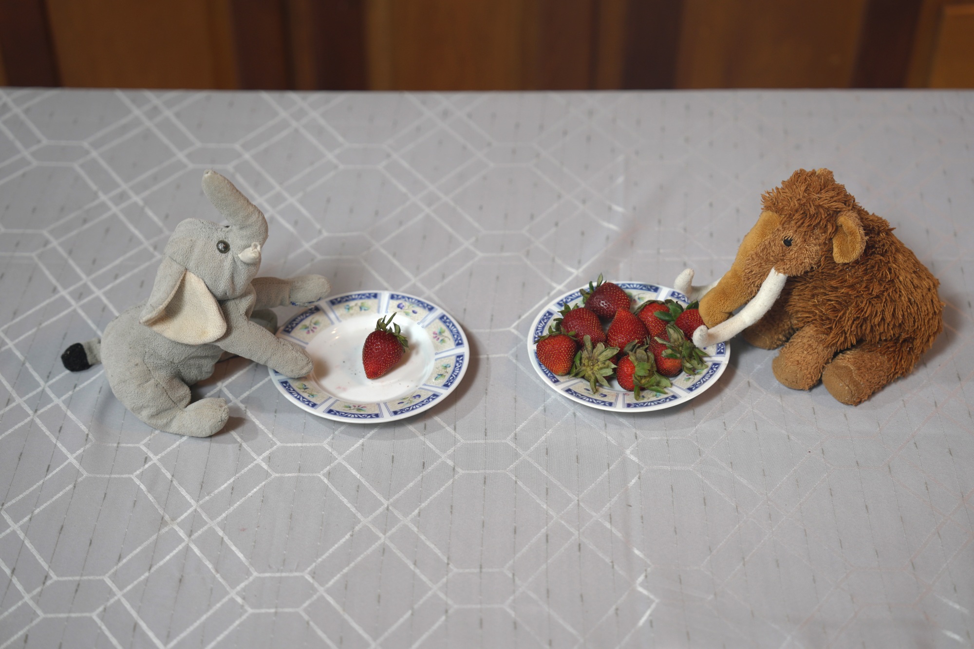 two stuffed animals with some strawberries on their plates