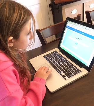 A girl practicing math problems online